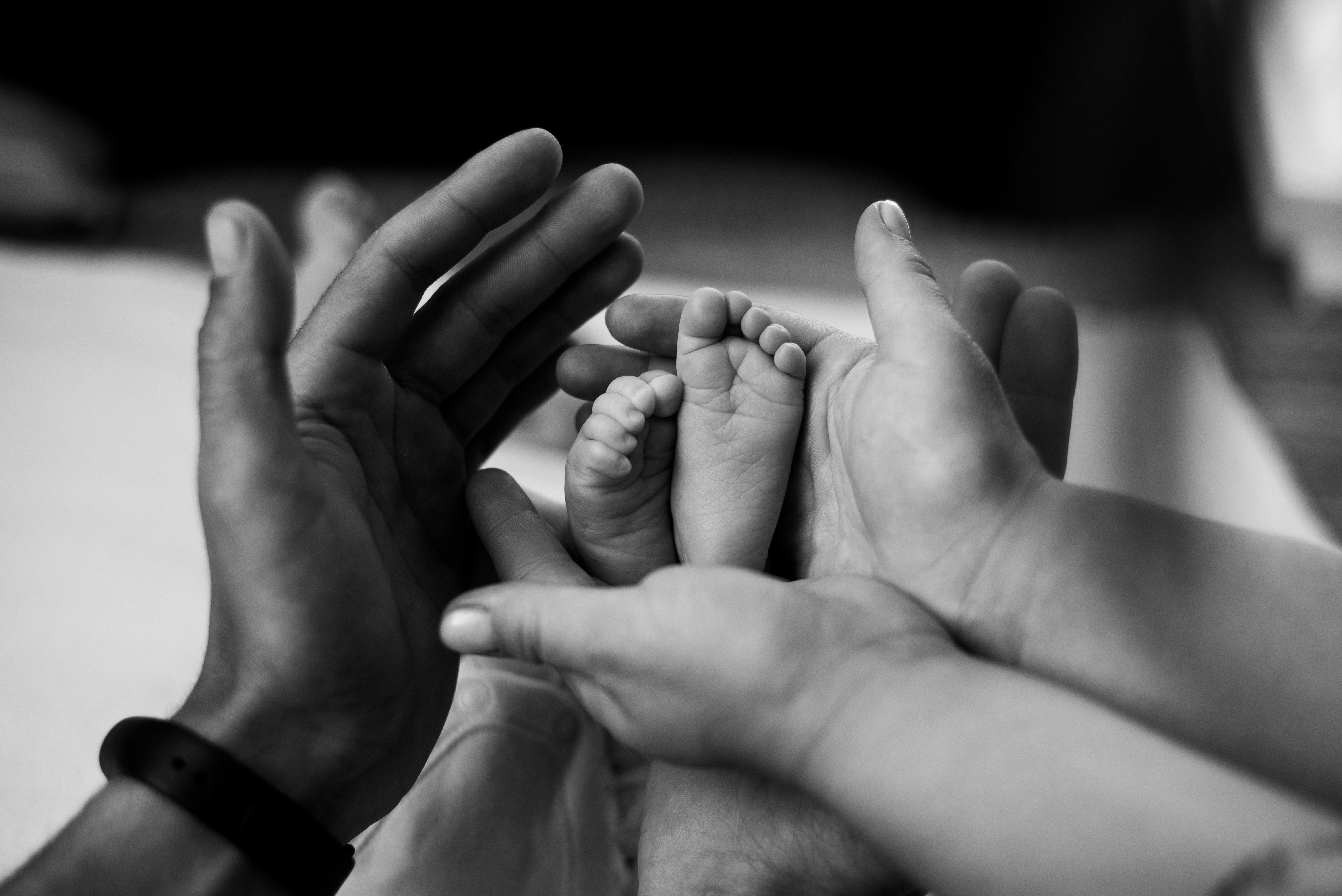 Naming day ceremony on the Sunshine Coast — parents' hands cradling a newborn baby's feet
